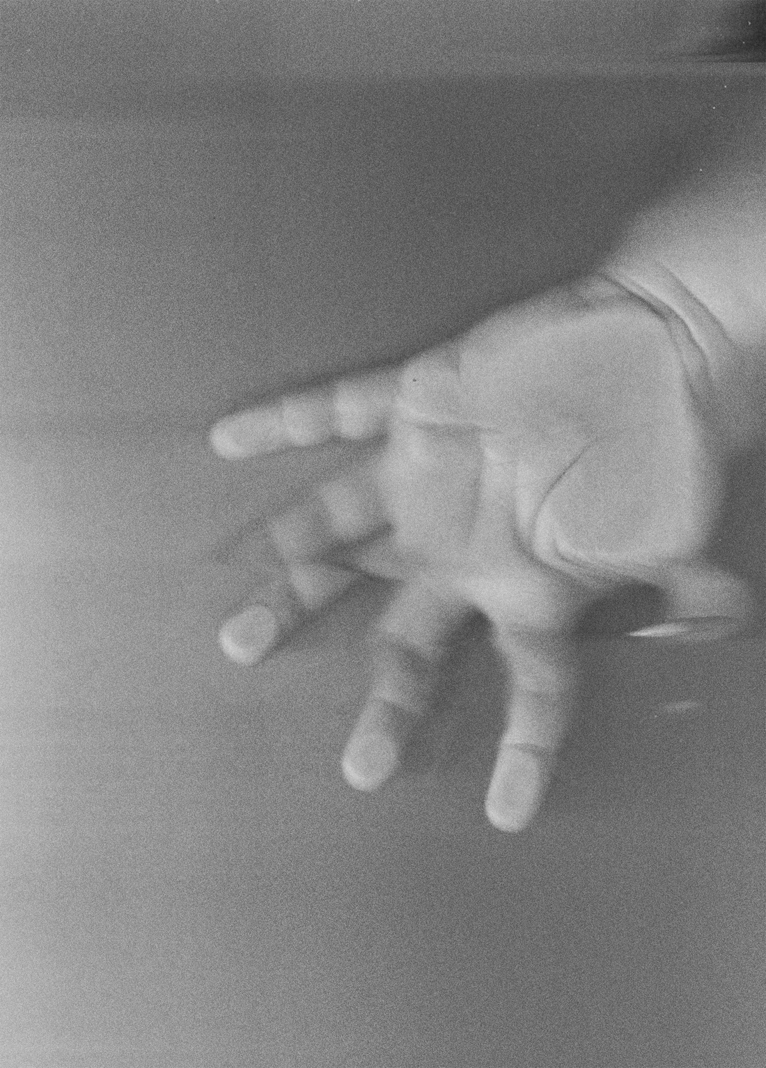 A baby's hand scanned on a flatbed scanner, the light stretching as he moved — black and white